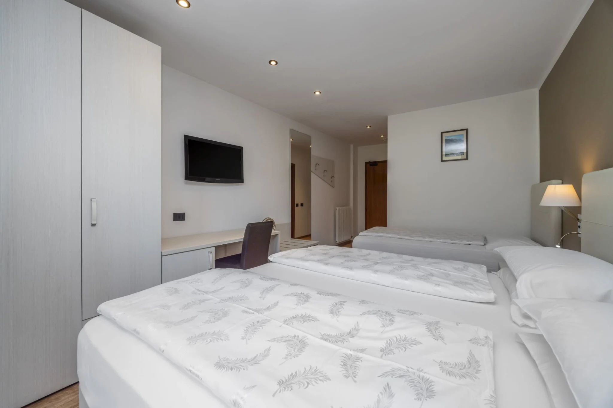 Camera tripla family classic con arredamento dalle linee pulite